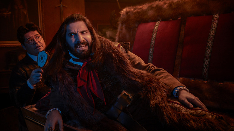 Guillermo brushes the hair of his vampire master Nandor The Relentless as he emerges from his coffin