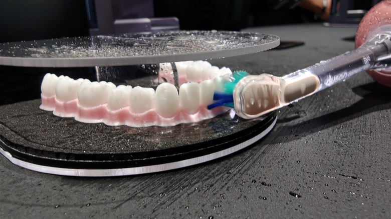 Dyson's CameraJet toothbrush cleaning some model teeth.