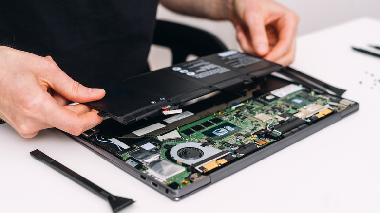 Derrubando um laptop e removendo a bateria.