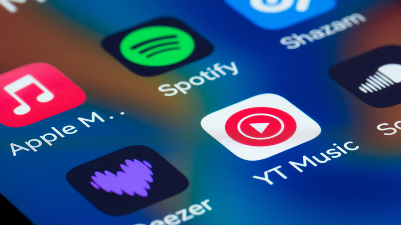 Close-up view of a smartphone screen displaying popular music streaming apps