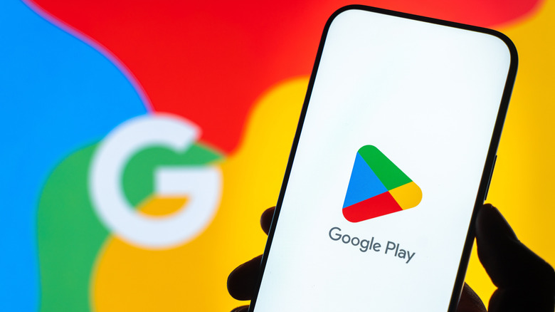 Photo shows a smartphone with the Google Play logo in front of an out-of-focus Google branded rainbow backdrop.