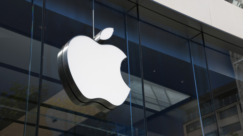Photo of the exterior of a glass and metal Apple store with the company's logo in white