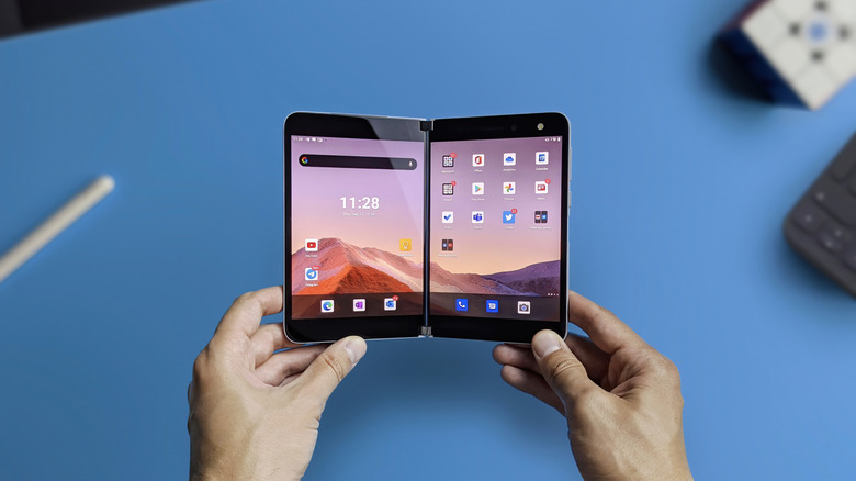 Two hands holding the Microsoft Surface Duo.