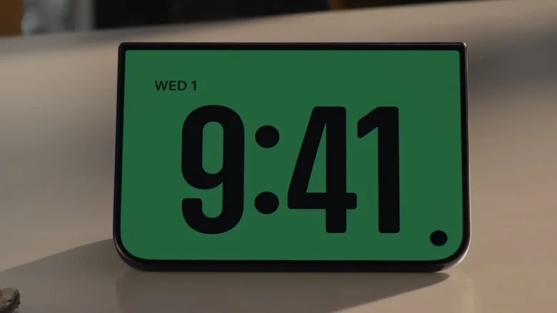 An iPhone Duo in kickstand mode shows the time.