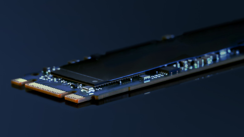 Close-up of an M.2 solid-state drive with exposed circuit board and memory chips.