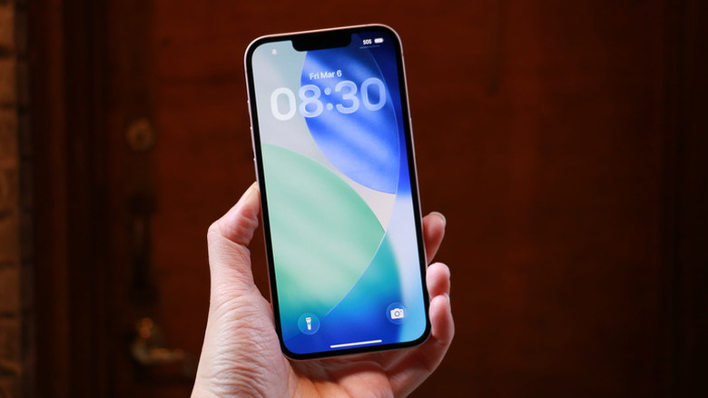A hand holding the iPhone 17e.