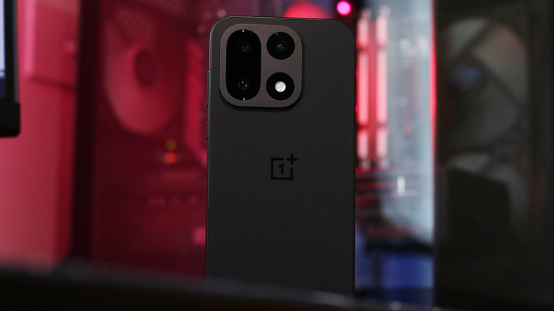 A OnePlus 15 in front of a PC