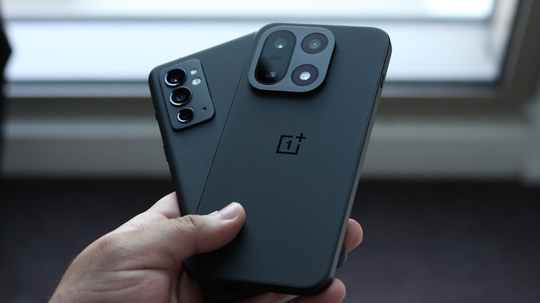 Person holding two OnePlus smartphones