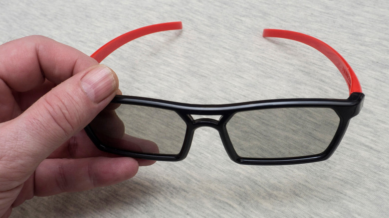A person holding IMAX 3D glasses.