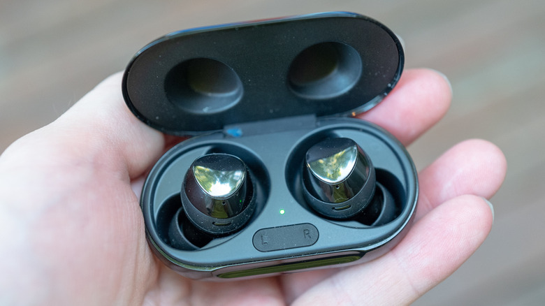 Close-up of wireless earbuds in hand.