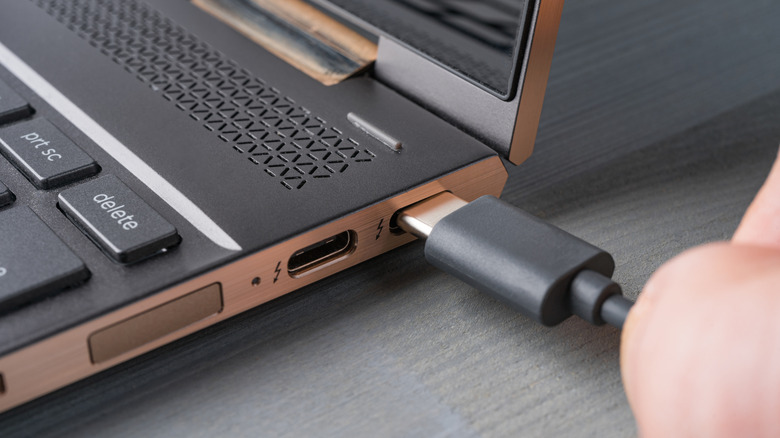 A USB-C charger being plugged into laptop.