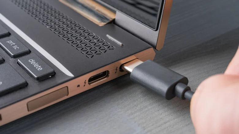 A USB-C charger being plugged into laptop.
