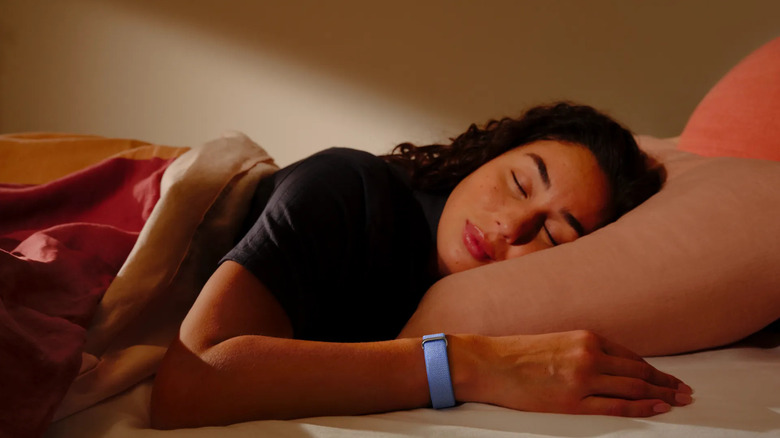 A woman tracking her sleep using the Google Fitbit Air.