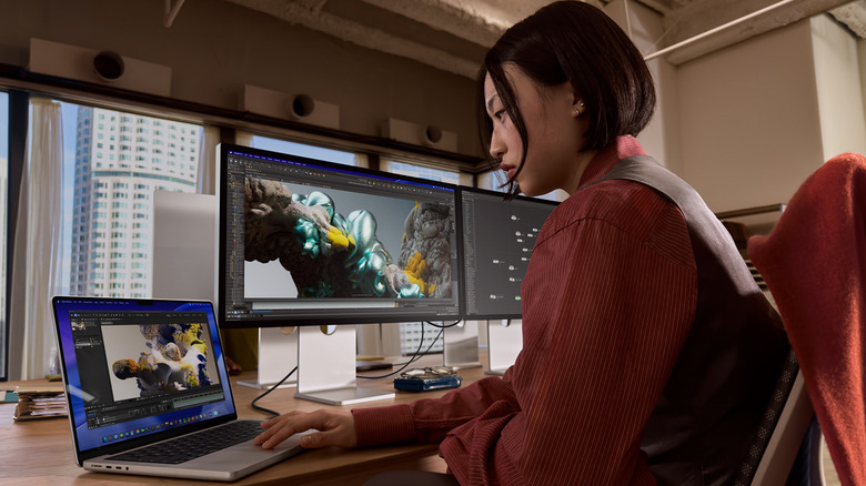 A woman at her desk working on a MacBook Pro M5.