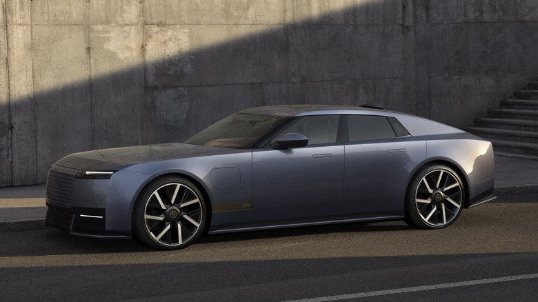 Jaguar's Type 01 EV is shown in a grey-blue color against a concrete wall