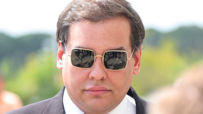 An expressionless man wearing sunglasses.