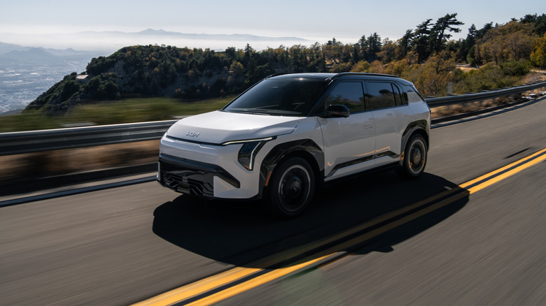 A Kia EV3 driving down a costal highway.