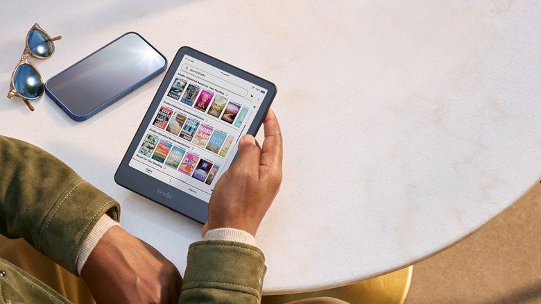 A person holding an Amazon Kindle ereader.