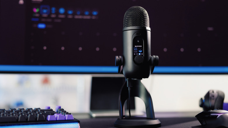 The Logitech G Blue Yeti 2 microphone sitting on a desk by a keyboard and monitor