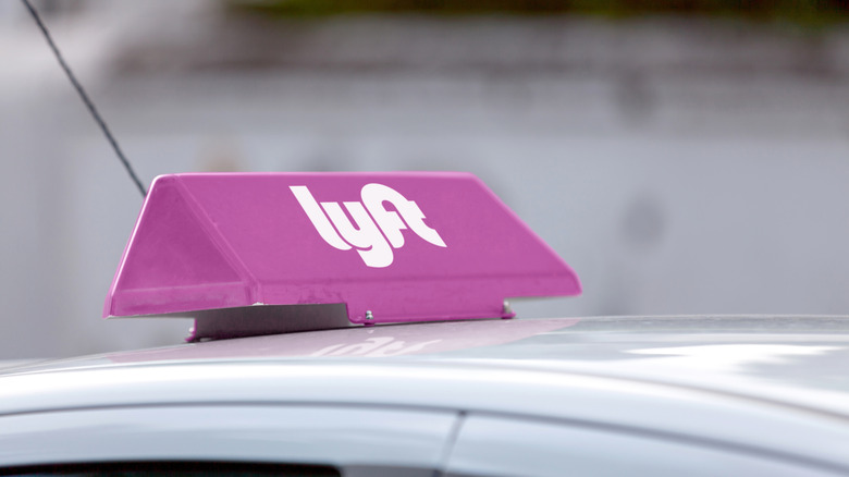 A Lyft sign on the top of a car.