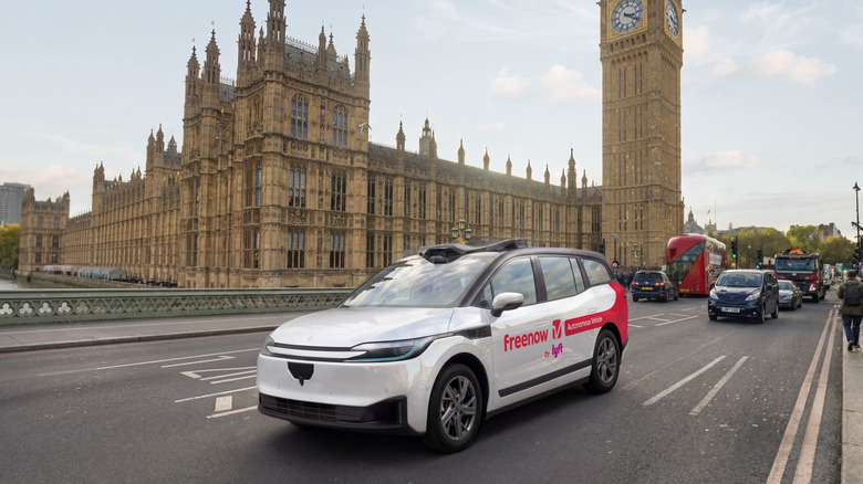 A Baidu Lyft robotaxi is shown testing in front of the UK parliament and Big Ben in London