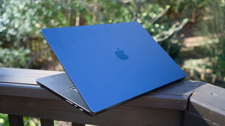 A 16-inch MacBook Pro is shown with the lid partially closed