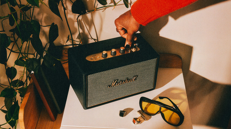 A hand pressing on speaker button.