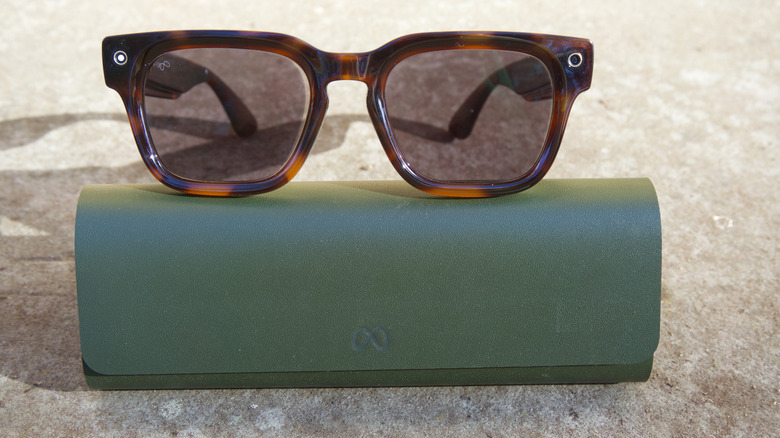Meta Glasses on top of their charging case with the recording LED on.