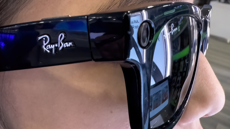 A person is wearing a pair of black Ray-Ban Meta smart glasses