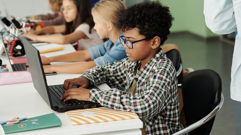 Elementary school children learning on laptops.