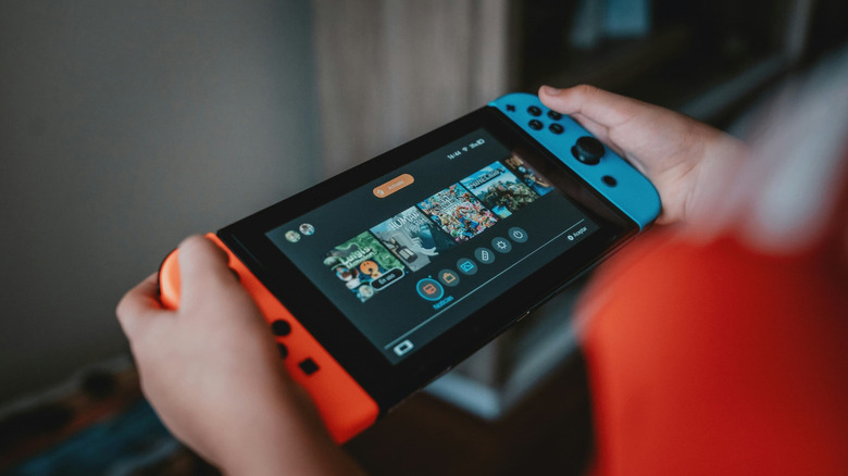 A person holding a Nintendo Switch console.
