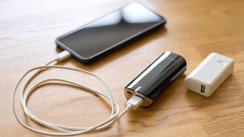 A small power bank charging a smartphone