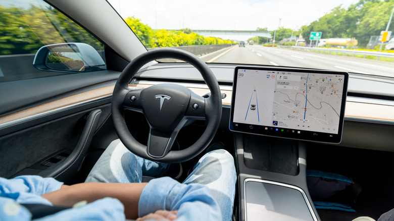 A man using FSD on a highway, with his hands off the steering wheel.