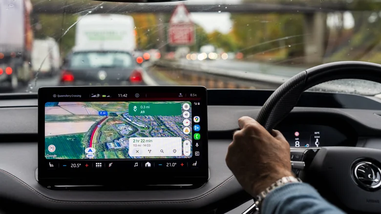 A driver using Google Maps for navigation on Android Auto.