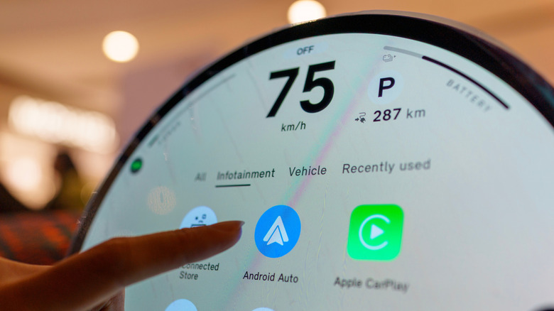 Closeup of a car's infotainment system showing Android Auto app icon.
