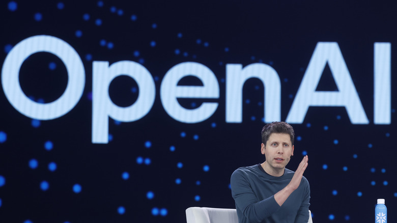Sam Altman in front of the OpenAI logo.