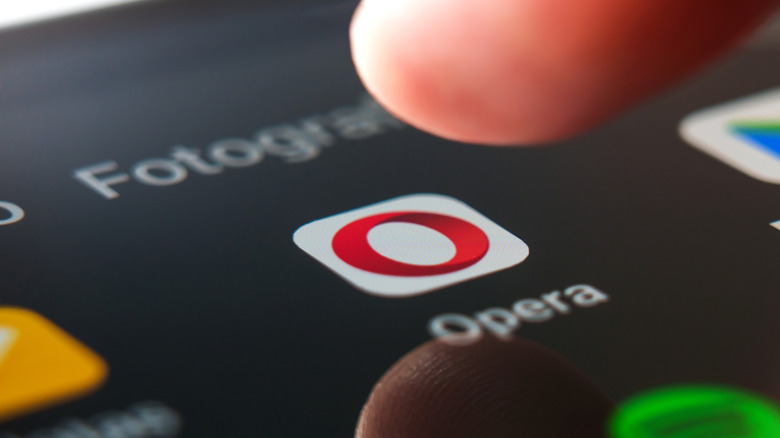 Opera browser logo shown on an Android smartphone with a fingertip hovering above