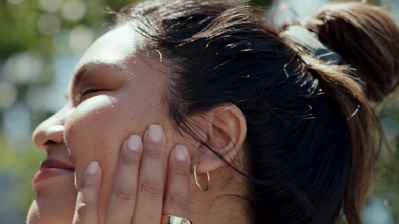 A woman wearing a smart ring in the sun.