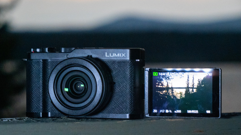 Panasonic Lumix L10 shown from the front with mountain's in the background