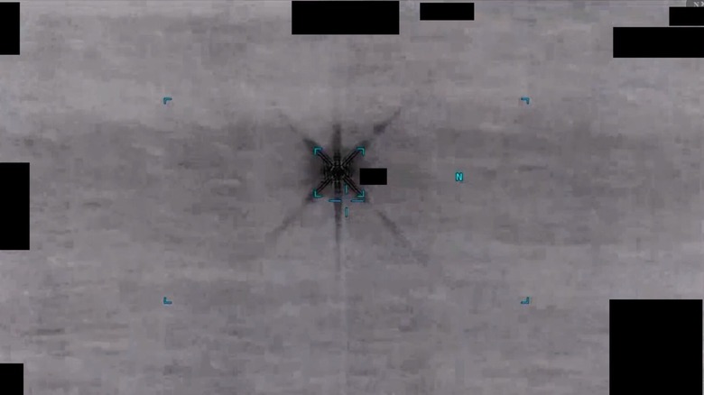 A black and white still frame from the UFO files showing an apparent sighting as a black target in the center of the image