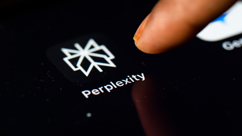 A finger touching a Perplexity app icon.