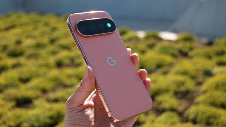 A person holding up the Pixel 11 Pro in mid-air with the HiLight indicator glowing green.