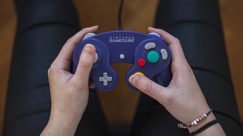 A person holding a GameCube controller.
