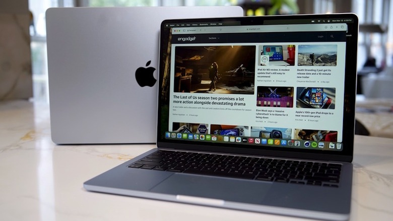 Photo of two silver MacBook laptops on a marble countertop.