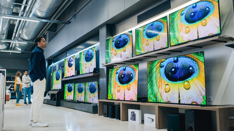 Man browsing the TV section of a big box store.