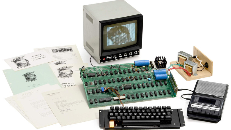 Various parts of an Apple I Computer, including a monitor with a bitmap image of a young Steve Jobs