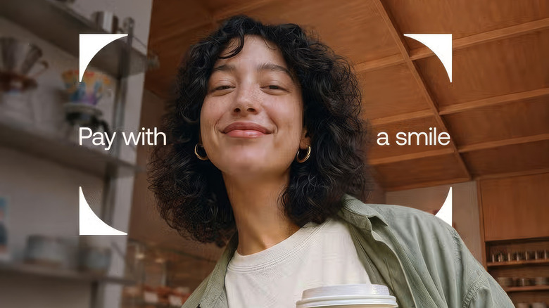 Revolut pay with a smile feature is illustrated with someone purchasing a coffee