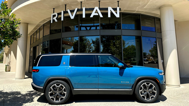 Photo of a blue Rivian electric vehicle in front of a showroom