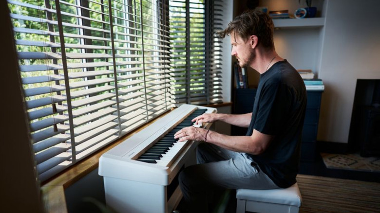 A man plays a piano intently.