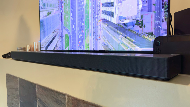 Samsung QS90H soundbar in front of a TV.
